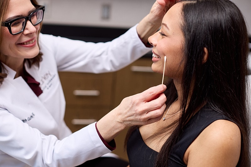 Healthcare professional examining a patient's skin.
