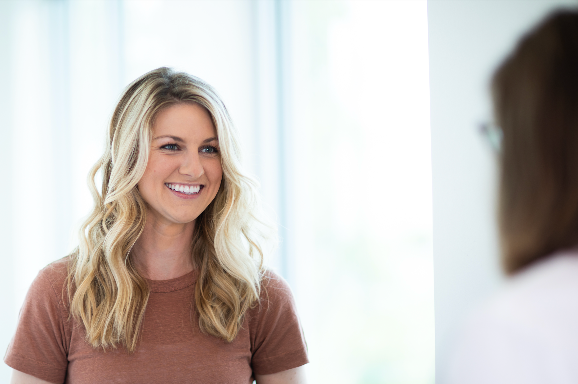 Smiling woman engaged in conversation indoors.