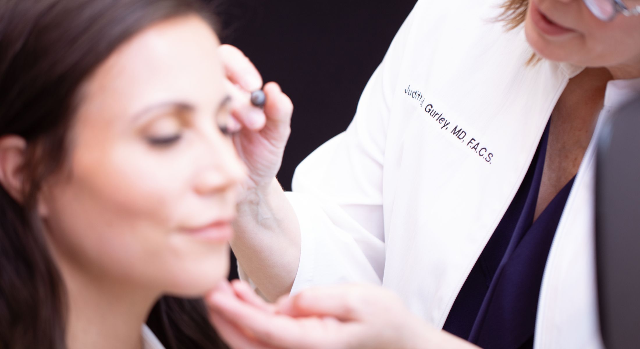 Doctor applying makeup on a client.