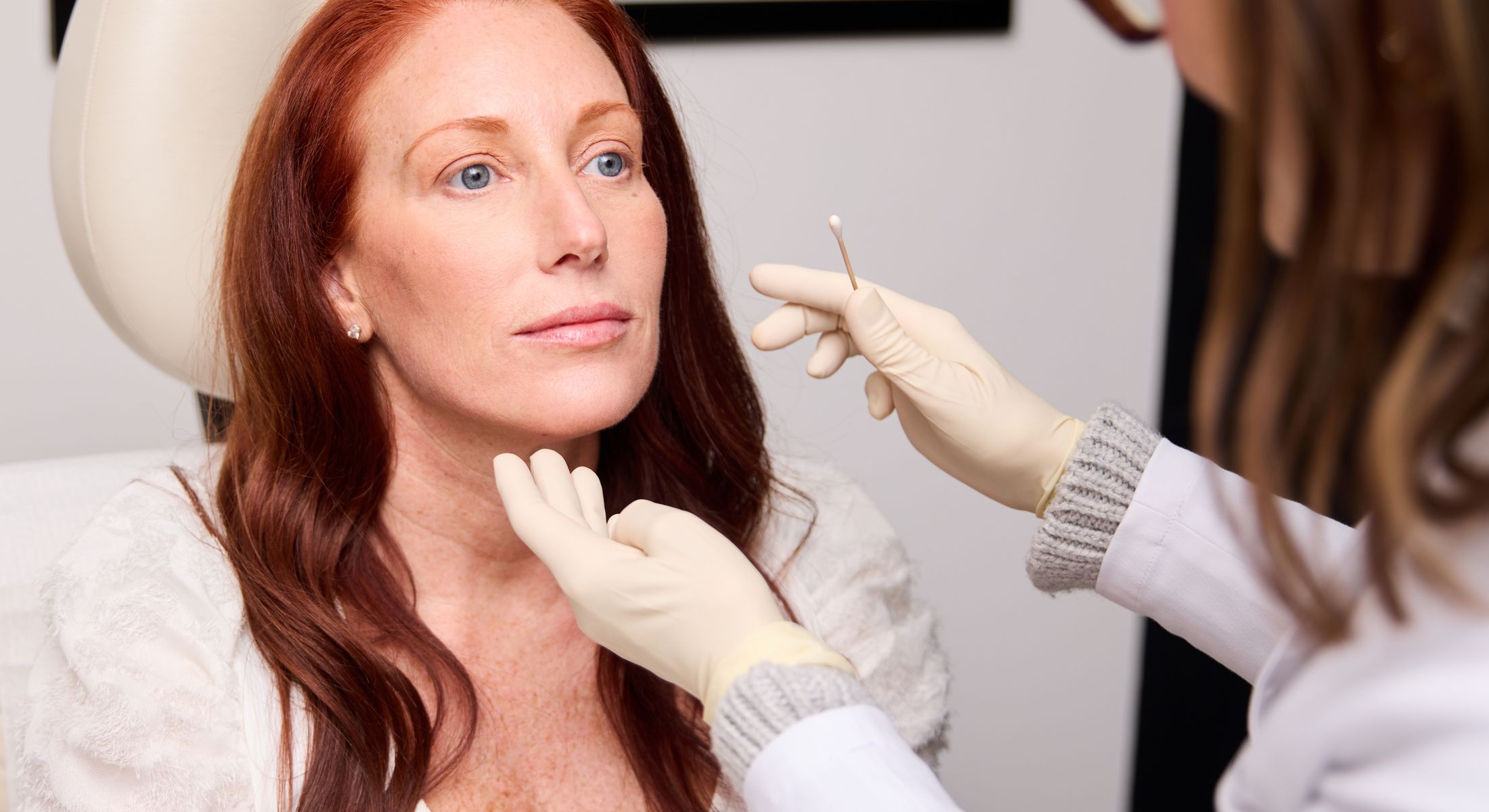 Woman receiving skincare treatment in clinic.